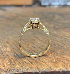 Diamond accented solitaire ring in 18 karat yellow gold